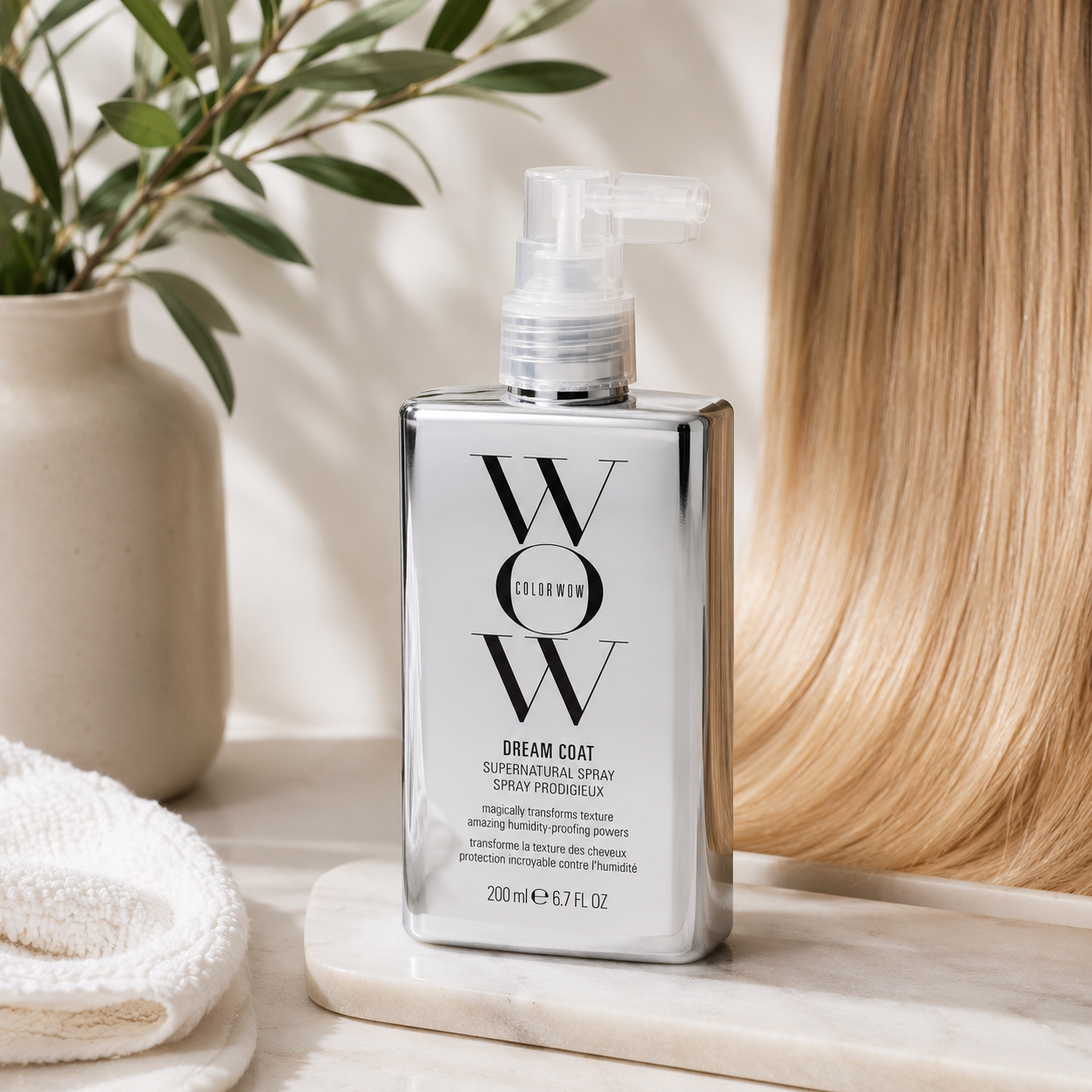Color Wow Dream Coat Supernatural Spray featured alongside silky blonde hair on a premium neutral background, illustrating a popular anti-frizz hair treatment that helps deliver smooth, shiny and humidity-resistant results.