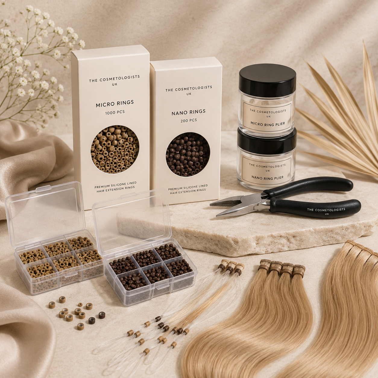 Luxury micro rings and nano rings hair extension accessories featuring silicone-lined beads, application tools and blonde hair extensions displayed on elegant beige stone surfaces in a premium salon-inspired setting.