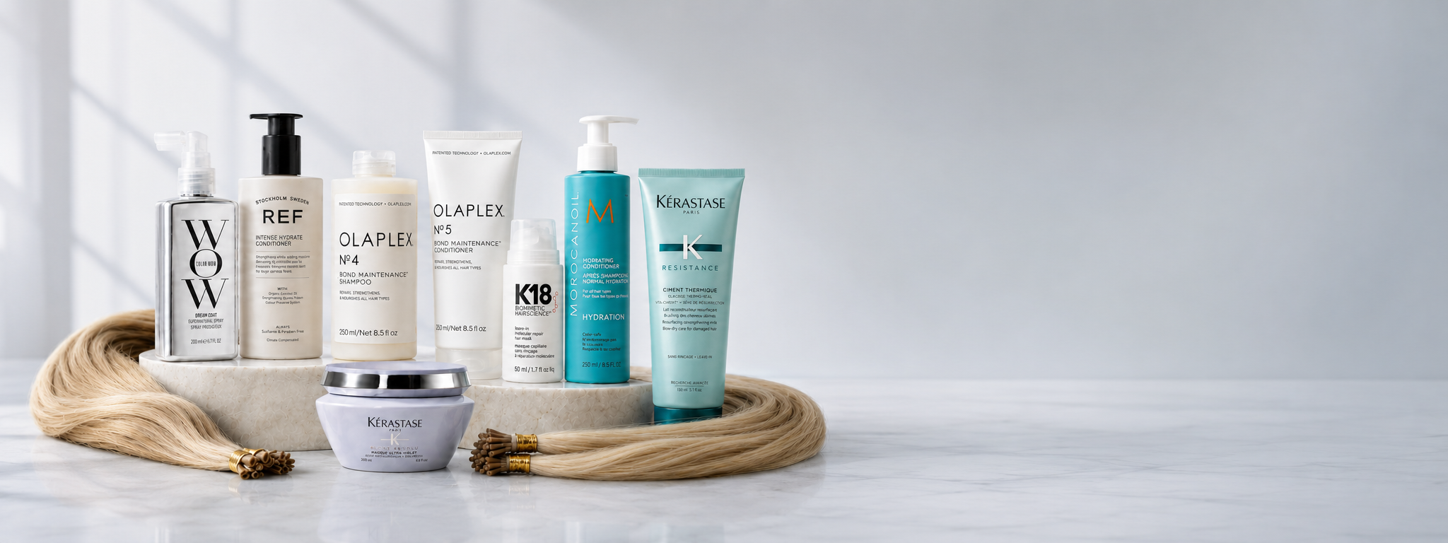 Luxury hair extension aftercare products including Colour Wow, REF, Olaplex, K18, Moroccanoil and Kérastase displayed with blonde hair extensions